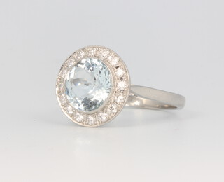 A platinum aquamarine and diamond cluster ring, the centre circular stone 2.5ct, the brilliant cut diamonds 0.35ct, 5.2 grams, size O