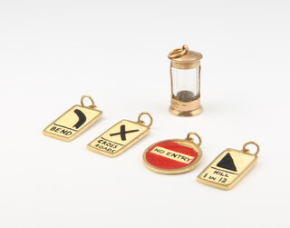 Four enamelled 9ct gold charms and a glass mounted ditto, gross weight 7.4 grams 