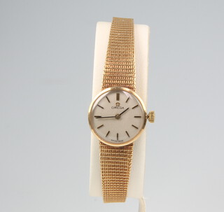 A lady's 9ct yellow gold Omega wristwatch contained in an 18mm case on a 9ct yellow gold mesh bracelet, gross weight including glass 18.8 grams 