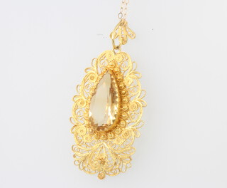 A filigree yellow metal pendant set with a citrine on a ditto chain, gross 5 grams