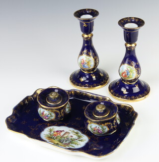 A 20th Century Dresden desk set comprising tray 24cm, pair of candlesticks 16cm and two ink pots 5cm, with blue and gilt ground with fete gallant scenes