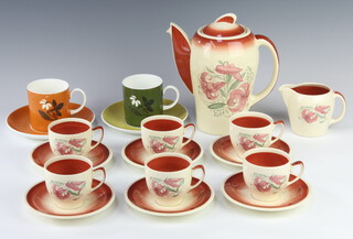 An Art Deco Susie Cooper coffee set comprising coffee pot, 6 cups, 6 saucers, milk jug decorated with stylised flowers together with a pair of Wedgwood Susie Cooper design coffee cans and saucers 