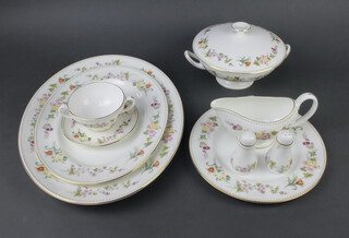 A Wedgwood Mirabelle pattern dinner service comprising 8 two handled bowls, 8 saucers, 8 small plates, 10 side plates, 8 dinner plates, small bowl, 2 oval meat plates, 2 vegetable dishes, 3 dishes and covers, a salt, a pepper and a sauceboat