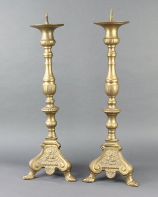 A pair of 17th Century style brass candlesticks, raised on panel supports 60cm h x 20cm w x 20cm d 