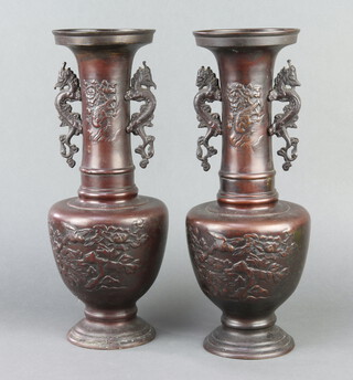 A pair of 19th Century Japanese bronze twin handled club shaped vases, raised on a circular spreading foot 38cm h x 11cm diam.  