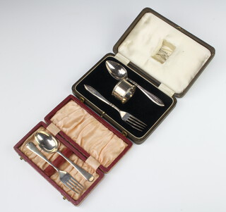 A cased silver fork and spoon Sheffield 1961 together with a cased napkin ring, fork and spoon 120 grams 
