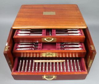 A mahogany 2 door canteen containing a set of silver handled lily pattern cutlery comprising 18 dessert knives, 18 dessert forks, 18 steak knives, a bread knife together with a sifter spoon