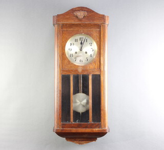 A 1930's 8 day striking wall clock, the 16cm silvered dial with Roman numerals, contained in an oak case 78cm h x 30cm w x 16cm d, complete with key and pendulum 