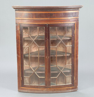 A Georgian inlaid mahogany hanging corner cabinet with moulded and dentil cornice, fitted shelves enclosed by astragal glazed panelled doors 113cm h x 89cm w x 61cm d 