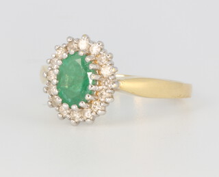 An oval emerald and diamond cluster ring, the oval cut emerald approx. 0.75ct, the brilliant cut diamonds 0.25ct, size L, 3.4 grams  