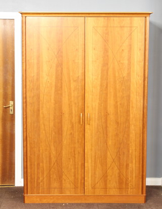 Richard Williams, a cherry wood wardrobe, the interior fitted trays, having columns to the side enclosed by a pair of panelled doors 200cm h x 137cm w x 60cm d 