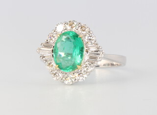 An 18ct white gold oval emerald and diamond cluster ring, the centre stone approx. 1.41ct, the baguette cut diamonds 0.17ct, the brilliant cut diamonds 0.65ct, size N 1/2, 4 grams, together with a WGI certificate