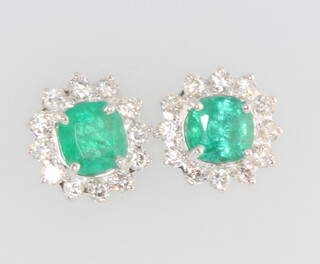 A pair of 18ct white gold emerald and diamond ear studs, the cushion cut emeralds approx. 2.17ct, the brilliant cut diamonds 0.98ct, 12mm x 12mm, 4.4 grams 