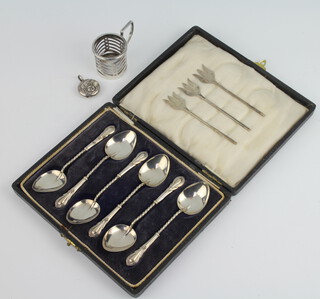 A set of 6 lily pattern silver coffee spoons, Birmingham 1925, 3 pickle forks, a rattle and a cup holder 60 grams gross
