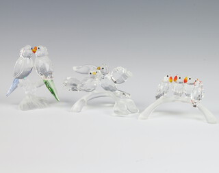 A Swarovski Crystal group of 4 parrots on a branch 10cm, a ditto of 2 doves 10cm and a pair of parrots 8cm, boxed