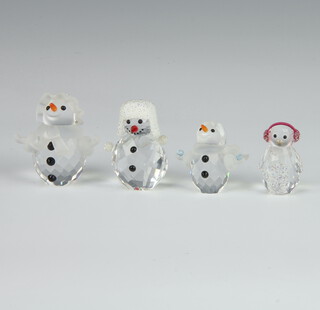 A Swarovski Crystal figure of a penguin wearing ear muffs 3cm, snowbaby 3.5cm, a Snowlady 5cm and a Snowman wearing a fur hat 5cm, boxed 