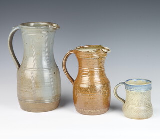 A Studio Pottery mug by Ray Finch with speckled decoration 10cm, ditto jug with incised decoration and tan ground 20cm and another with incised geometric decoration 27cm  