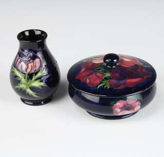 A contemporary Moorcroft blue ground pot and cover decorated with anemones 12cm together with a baluster vase decorated with anemones 9cm 