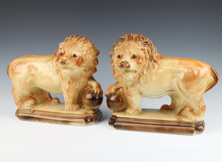 A pair Victorian Staffordshire figures of lions with glass eyes raised on rectangular plinths 26cm 