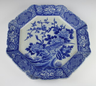 A late 19th Century Japanese transfer print octagonal plate with a band of lines and flowers enclosing a panel of an exotic bird beneath trees 43cm 
