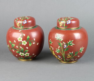 A pair of red ground and floral patterned cloisonne enamelled jars and covers 14cm x 8cm (1 with slight bruise) 