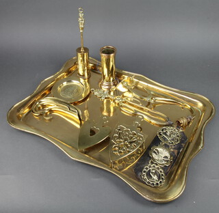 A rectangular brass tea tray 64cm x 46cm, 2 brass iron stands, 4 brass shoe horns, ditto poker stand, fire tongs, fire brush, brass wall light bracket, ashtray decorated the badge of the Royal Army Medical Corps and a brass martingale hung 3 horse brasses 