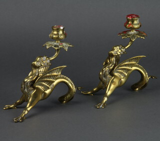 A pair of Victorian brass candlesticks in the form of griffins with outstretched wings 7cm x 10cm x 20cm 