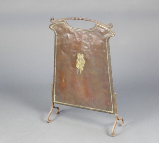 An Art Nouveau copper, brass and iron fire screen decorated musical trophies 70cm h 