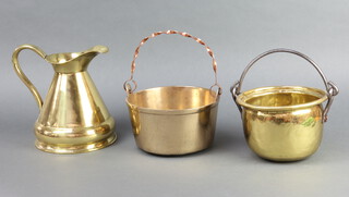 A brass preserving pan with copper swing handle 10cm h x 8cm (old repair), a planished brass pail with polished steel handle 10cm x 16cm and a waisted brass jug 18cm x 17cm 