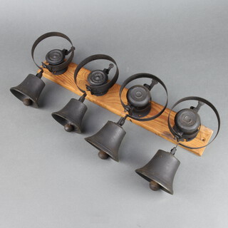 Four 19th Century servant bells mounted on a pine board, two numbered 10, one numbered 12 and 1 unmarked 
