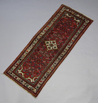 A Persian red, white and green patterned Malayer runner with central diamond medallion 202cm x 80cm 
