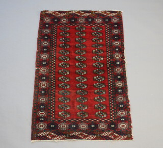A red and blue ground Bokhara rug with 42 octagons to the centre within a multi row border (in wear) 127cm x 80cm 
