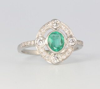 A platinum Art Deco style oval emerald and diamond cluster ring, the centre stone approx 0.65ct surrounded by brilliant cut diamonds 0.3ct, 4 grams, size N 1/2