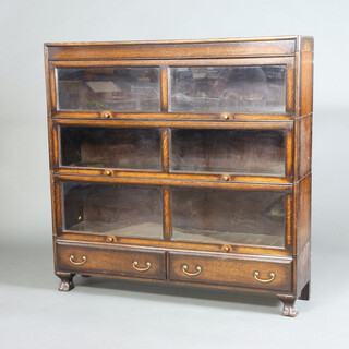 An oak Globe Wernicke style 3 tier bookcase enclosed by glass sliding panelled doors, the base fitted 2 drawers, raised on 4 supports 128cm h x 128cm w x 31cm d 

