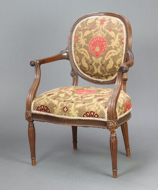 A 1930's carved mahogany open arm salon chair, the seat and back upholstered in floral material, raised on turned and reeded supports 92cm h x 67cm w x 46cm d (seat 40cm x 35cm) 