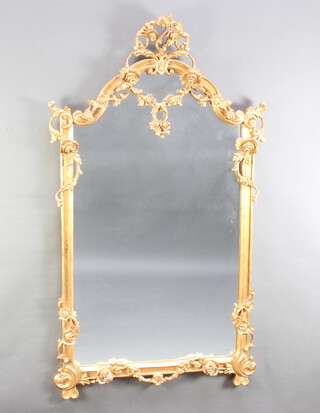 A 20th Century Rococo style mirror contained in a carved gilt wood frame 157cm x 88cm 
