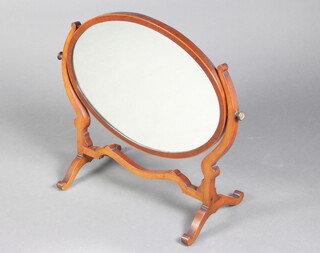 A 19th Century oval bevelled plate dressing table mirror contained in a mahogany swing frame 59cm h x 51cm w x 29cm d 