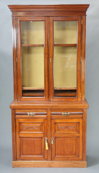 An Edwardian Art Nouveau mahogany cabinet on cabinet, the upper section with moulded cornice, the interior fitted adjustable shelves enclosed by glazed panelled doors, the base fitted 2 long drawers above a double cupboard enclosed by panelled doors 224cm h x 117cm w x 45cm d  
