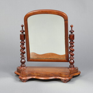 A Victorian arched plate dressing table mirror contained in a mahogany frame with spiral turned columns to the sides, on a shaped base 65cm h x 63cm w x 28cm d 
