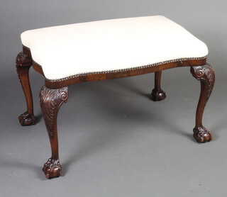 A 1920's carved Chippendale style mahogany stool of serpentine outline with overstuffed seat, raised on cabriole supports 47cm h x 72cm w x 45cm d 