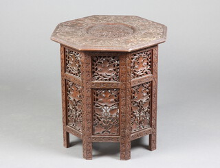 A 19th Century octagonal pierced and carved Indian hardwood occasional table, raised on a  folding stand with leaf decoration 55cm h x  52cm w x 53cm d 