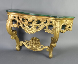 A gilt painted carved wood console table of serpentine outline with green painted faux top 85cm h 141cm x 47cm d 