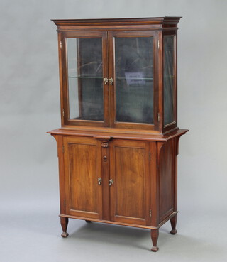 An Edwardian display cabinet on cabinet, the upper section with moulded cornice fitted a shelf enclosed by glazed panelled door, the base fitted a shelf and a drawer enclosed by a panelled door, raised on shaped supports 155cm h x 90cm w x 47cm d 