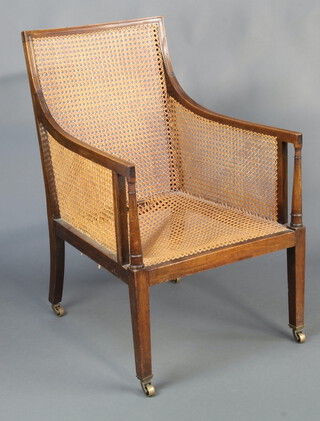 A Georgian style mahogany library chair with caned seat and back, raised on square supports ending in brass caps and casters 95cm h x 60cm w x 64cm d (seat 38cm x 45cm)  
