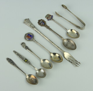 A silver pickle fork and minor silver souvenir spoons 134 grams 