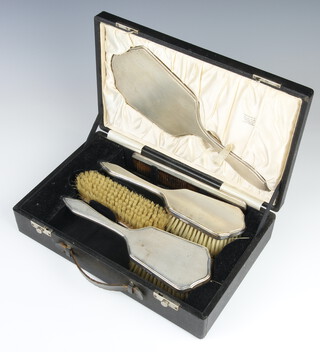 An Art Deco style cased silver engine turned dressing table set comprising hand mirror, 2 hair brushes, clothes brush and comb London 1964
