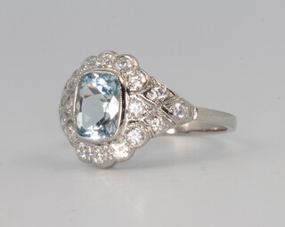 A platinum Edwardian style cushion cut aquamarine and diamond ring, the centre stone 1.2ct, the brilliant cut diamonds 0.65ct, 5 grams, size N 1/2