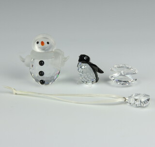 A Swarovski Crystal figure of a snowman 5cm, penguin 3.5cm, clam shell 2cm and a Christmas tree decoration 2cm 