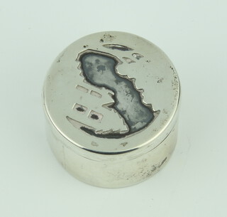 A silver circular pill box the lid decorated with an island 44.2 grams, 4cm, London 1976  
