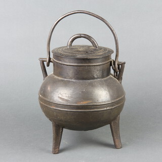 An iron cauldron complete with lid and swing handle 21cm h x 14cm w 